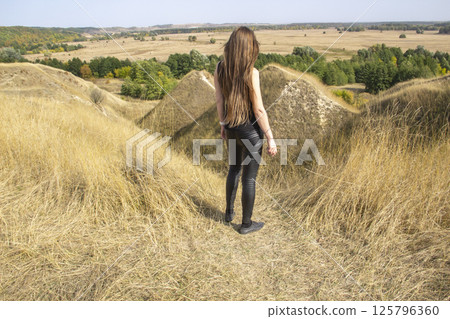 Beautiful strong dark haired woman in black clothes outdoor in the nature enjoy with freedom 125796360