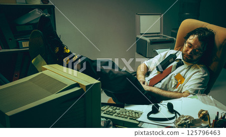 Exhausted office worker falls asleep in his chair with his feet up on messy desk, burnout and mental fatigue after long hours in retro office setting Exhausted office worker falls asleep in his chair with his feet up on messy desk, burnout and mental fatigue after long hours in retro office setting 125796463