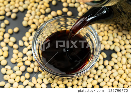 Close-up of the process of pouring soy sauce into a saucepan. 125796770
