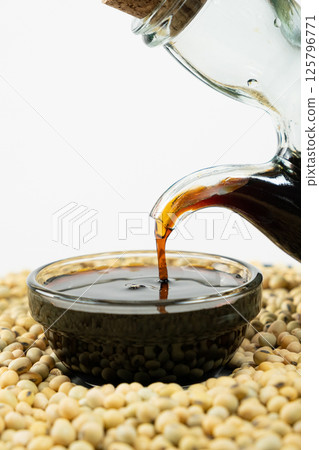 Close-up of the process of pouring soy sauce into a saucepan. 125796771