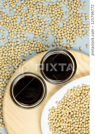 Soy sauce bowls among raw soybeans top view 125796772