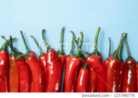 Sharp and Spicy Chili Peppers Top View on Blue Background 125796779