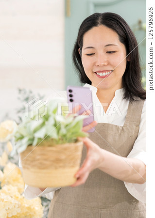 中年婦女在室內拍攝植物 |花店園藝店教室圖片|幸福女孩 |福利 中年婦女在室內拍攝植物 |花店園藝店教室圖片|幸福女孩 |福利 125796926