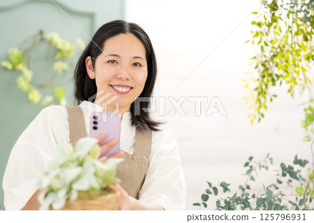 中年婦女在室內拍攝植物 |花店園藝店教室圖片|幸福女孩 |福利 125796931