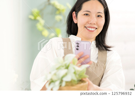 中年婦女在室內拍攝植物 |花店園藝店教室圖片|幸福女孩 |福利 125796932