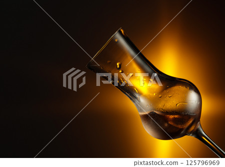 Snifter with strong alcoholic drink. 125796969