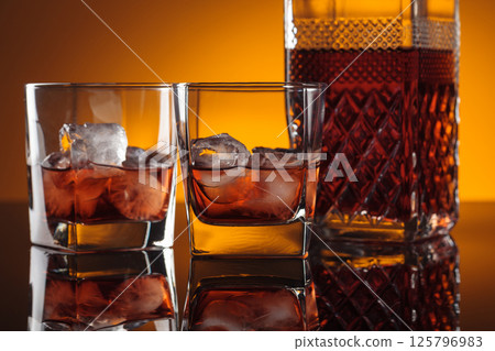 Whiskey with ice on a reflective background. 125796983