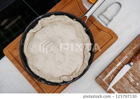Unbaked rustic fruit galette is preparing outdoors. 125797130
