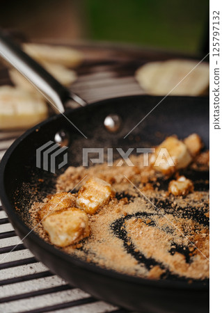 Melting brown sugar and butter in pan for dessert. 125797132