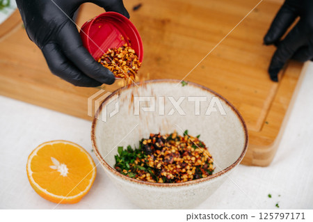 Chef preparing fresh chimichurri sauce with herbs and olive oil. Chef preparing fresh chimichurri sauce with herbs and olive oil. 125797171