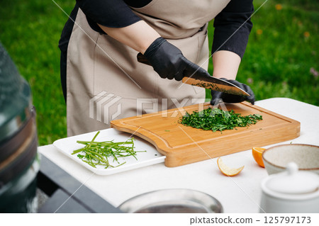 Chef preparing fresh chimichurri sauce with herbs and olive oil. 125797173