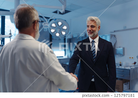 Portrait of pharmaceutical sales representative shaking hand with doctor. 125797181