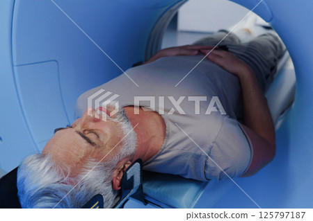 Male patient undergoing CT scan examination in hospital. 125797187