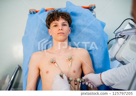 Preoperative EKG examination of teenage patient in hospital setting. 125797205