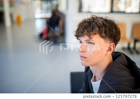 Teenage boy waiting alone in hospital waiting area before medical checkup. 125797278
