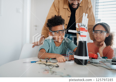 Parents encouraging children to explore robotics and technical skills. 125797285