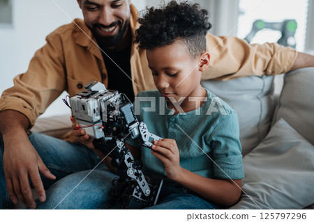 Father teaching son about STEM, robotics, and discussing technology. 125797296