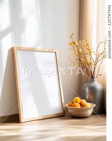 Blank frame for wall art mockup with modern decor featuring a vase and bowl of fruit. Minimalist white living room interior. 125797442