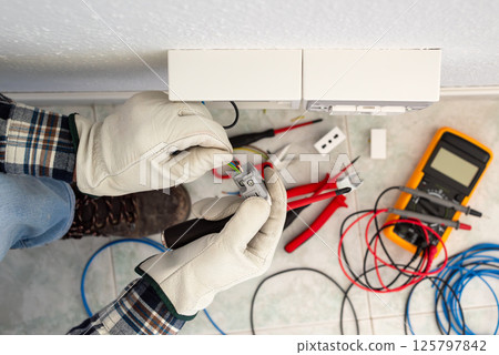 Electrician at work on a residential electrical system. Electricity. 125797842