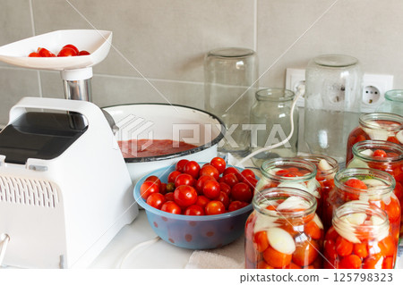 Homemade tomato preserves and tomato juice, canned and sealed for winter storage, maintaining flavor and freshness 125798323