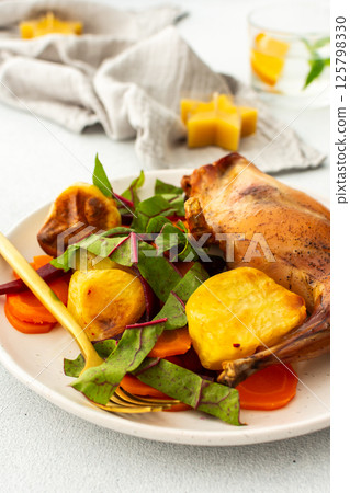 Enjoy a delicious, hearty meal with baked rabbit, roasted potatoes, and carrot salad, combining savory flavors and wholesome ingredients for a nutritious and satisfying dinner Enjoy a delicious, hearty meal with baked rabbit, roasted potatoes, and carrot salad, combining savory flavors and wholesome ingredients for a nutritious and satisfying dinner 125798330