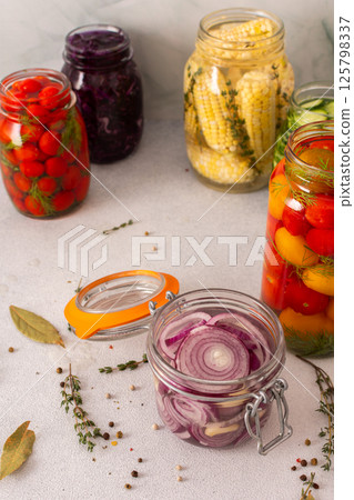Fresh red onion fermenting in a jar with spices, creating a healthy probiotic-rich food, fresh fermenting vegetables like cabbage, tomatoes, cucumbers , corn 125798337