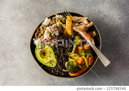 Nutritious, wholesome breakfast featuring quinoa, avocado, roast chicken, and roasted vegetables like sweet potato, zucchini, and broccoli, complemented with a fresh cabbage and radish salad Nutritious, wholesome breakfast featuring quinoa, avocado, roast chicken, and roasted vegetables like sweet potato, zucchini, and broccoli, complemented with a fresh cabbage and radish salad 125798340