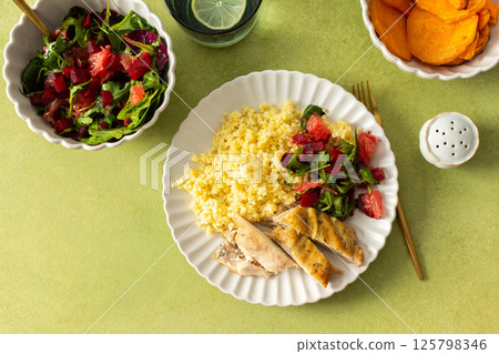 A wholesome and nutritious breakfast featuring millet, baked chicken breast, a fresh salad with greens and grapefruit, and roasted sweet potatoes, perfect for a healthy start A wholesome and nutritious breakfast featuring millet, baked chicken breast, a fresh salad with greens and grapefruit, and roasted sweet potatoes, perfect for a healthy start 125798346