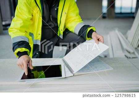 Construction site manager using digital tablet to inspect building progress. Construction site manager using digital tablet to inspect building progress. 125798615