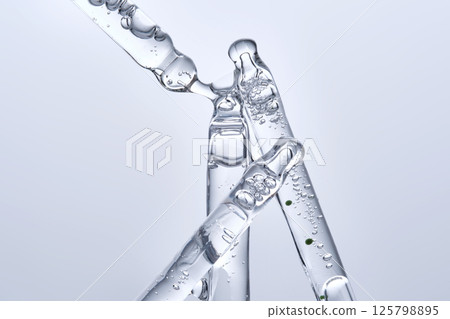 Four different face serum pipettes on a neutral background. 125798895