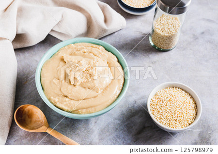 Homemade sesame tahini in bowl on grey table 125798979