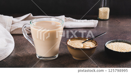 Tahini latte with sesame spread in a cup on the table web banner Tahini latte with sesame spread in a cup on the table web banner 125798995