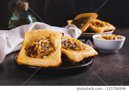 Upside down tarts with caramelized onions on a plate on a table 125798996