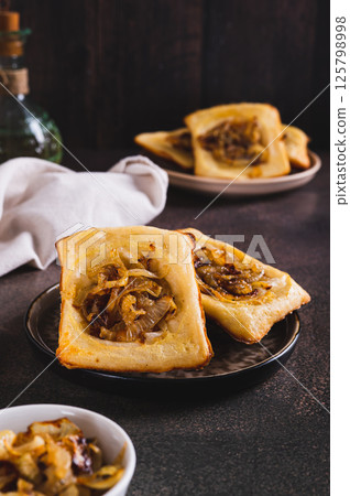 Upside down tarts with caramelized onions on a plate on a table vertical view Upside down tarts with caramelized onions on a plate on a table vertical view 125798998