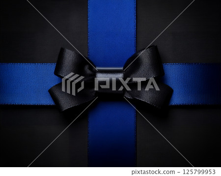 A present wrapped in black paper with a blue ribbon and a black bow centered on the package top 125799953
