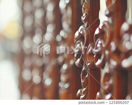 Close up of an ornate wooden screen with carved details and shallow depth of field creating bokeh effect 125800207