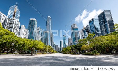 Vibrant city skyline in Shenzhen shows modern architecture along an empty asphalt road under a bright blue sky 125800709