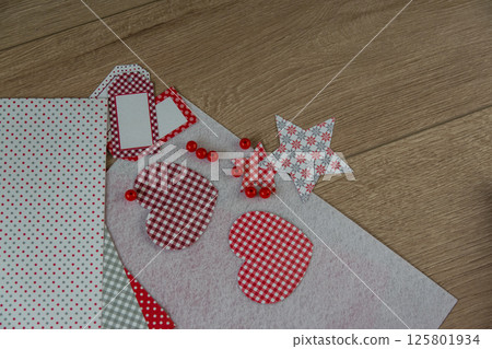 The red heart made of paper, handwork, and other materials for creation of a congratulation by Valentines Day or Mothers day on the wood table. Cold background. Hobby for children concept. 125801934