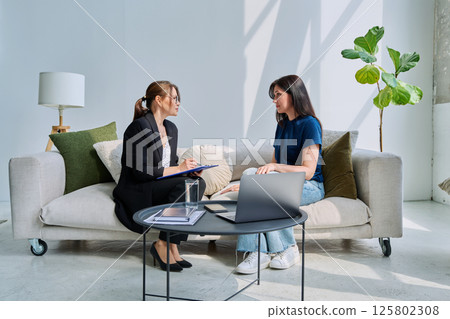 Young woman patient at mental therapy session, talking with psychologist 125802308