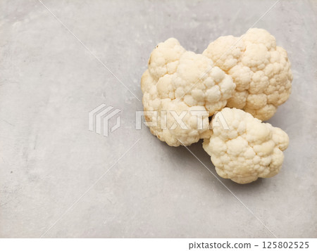Fresh cauliflower florets resting on gray surface copy space preparing vegetables for making soup Fresh cauliflower florets resting on gray surface copy space preparing vegetables for making soup 125802525