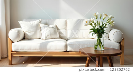 Simple living room with white sofa, decorations, and perfect everyday lighting. 125802762