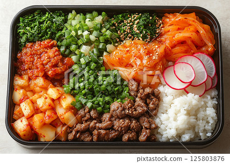 Korean-style lunch box with bibimbap ingredients, kimchi and pickled radish. Container with dosirak. Korean-style lunch box with bibimbap ingredients, kimchi and pickled radish. Container with dosirak. 125803876