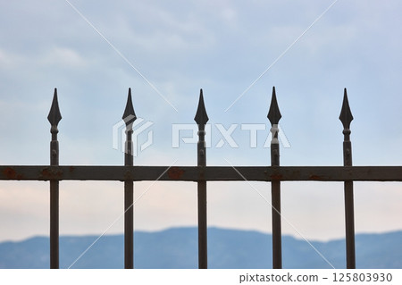 Forged iron fence rods and clouds Forged iron fence rods and clouds 125803930