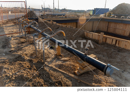 A close-up view of a series of flexible hoses connected to a pipe at a construction site A close-up view of a series of flexible hoses connected to a pipe at a construction site 125804111