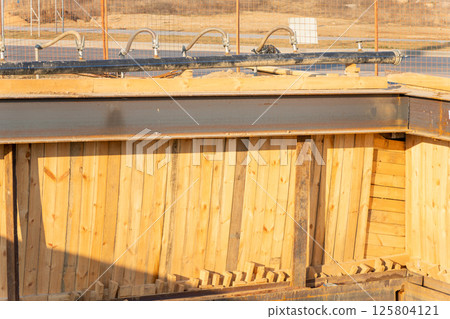 View of a series of flexible hoses connected to a pipe at a construction site 125804121