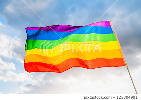 LGBTQ Pride Flag on cloudy sky LGBTQ Pride Flag on cloudy sky 125804991
