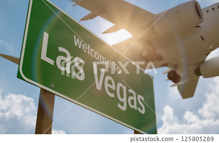 Welcome To Las Vegas Green Road Sign with Low Flying Airplane Just Above with Landing Gear Down. 125805289