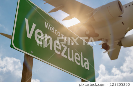 Welcome To Venezuela Green Road Sign with Low Flying Airplane Just Above with Landing Gear Down. 125805290