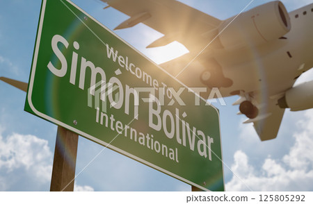 Welcome To Simon Bolivar International Airport Green Road Sign with Low Flying Airplane Just Above with Landing Gear Down. 125805292