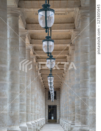 Corridor perspective with Columns and Antique lantern hanging from Ceiling inside of the Courtyard of the Honor gallery. 125805645